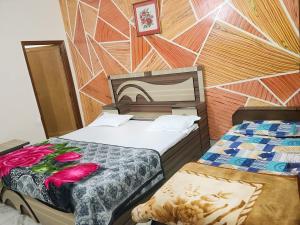 a hotel room with two beds with flowers on it at Hotel Hari Krishnashrya in Vrindāvan