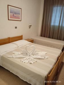 Una cama con dos toallas blancas. en Hotel Europa, en Gabicce Mare