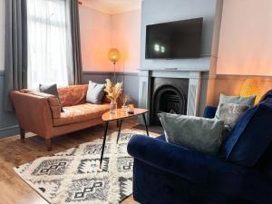 uma sala de estar com dois sofás e uma televisão em House with parking and fast trains to Central London em Croydon