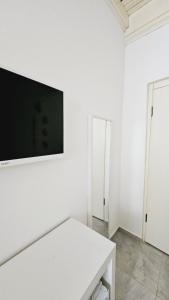 a white room with a tv on a white wall at Ada Kalimera Bozcaada in Bozcaada