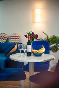 orbi city pearl hotel في باتومي: طاولة مع زجاجة من النبيذ ووعاء من الموز