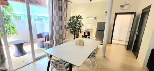 una sala da pranzo con tavolo e sedie bianchi di Number 3, Pebble Bay Appartments, Ground floor a Pereybere