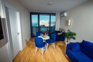 orbi city pearl hotel في باتومي: غرفة معيشة مع أريكة زرقاء وطاولة