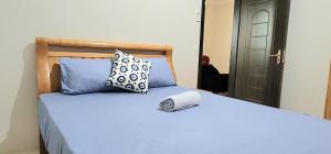 un letto con cuscini blu e un libro sopra di Number 3, Pebble Bay Appartments, Ground floor a Pereybere