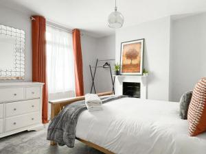 um quarto branco com uma cama e uma lareira em House with parking and fast trains to Central London em Croydon