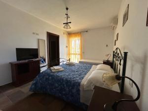 una camera da letto con un letto con una coperta blu e una TV di Agriturismo La Lucia a Sant'Isidoro
