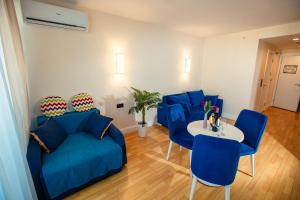 uma sala de estar com cadeiras azuis e uma mesa em orbi city pearl hotel em Batumi