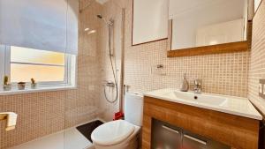 Un baño con inodoro, lavabo y ducha. en Click & Guest - Maspalomas Dunes Whisper, en San Bartolomé