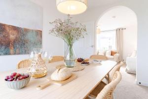 una mesa de comedor con un jarrón de flores en Rosandric, en Bude