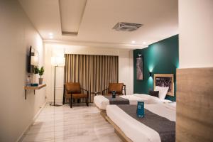 um quarto de hotel com duas camas e uma cadeira em LOKAL Rooms x Murree Valley View em Murree