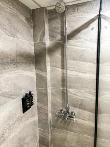 um chuveiro com uma porta de vidro na casa de banho em LOKAL Rooms x Murree Valley View em Murree