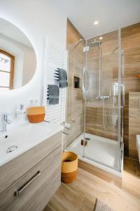 a bathroom with a glass shower and a sink at Lake house with sun terrace for 8 guests in Herrsching am Ammersee