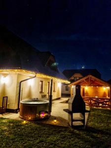 a backyard with a hot tub and a house at night at Vila Svistovka in Stará Lesná