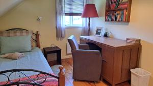 a bedroom with a desk and a bed and a desk at Elvebakk Bed & Breakfast in Reed