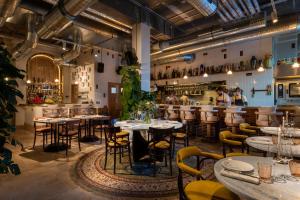 ein Restaurant mit Tischen und Stühlen und eine Bar in der Unterkunft The Tale Luxury Suites in Berlin
