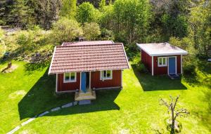 una pequeña casa con techo rojo en un campo verde en Gorgeous Home In Strmstad With House Sea View, en Strömstad