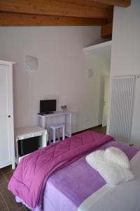 a bedroom with a purple bed and a desk at B&B Il Barsot in Pettenasco