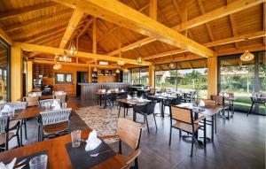 un restaurante con techos de madera, mesas y sillas en Awesome Home In Bilje With Outdoor Swimming Pool, en Bilje