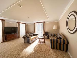 ein Wohnzimmer mit 2 Sofas und einem Flachbild-TV in der Unterkunft Scuol Palace Bed & Breakfast in Scuol