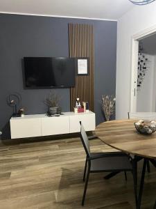 a living room with a table and a tv on a white cabinet at Il rifugio tra gli ulivi in Ortona