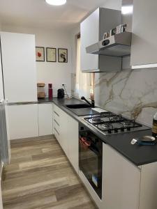 a kitchen with white cabinets and a stove top oven at Il rifugio tra gli ulivi in Ortona