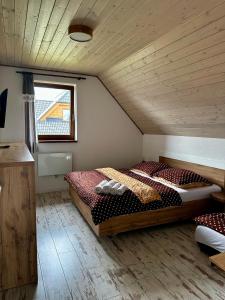 sypialnia z dużym łóżkiem na poddaszu w obiekcie Vila Svistovka w Starej Leśnej