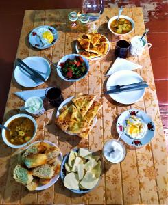 una mesa con platos de comida en una mesa en Gujejiani Guest house, en Mestia