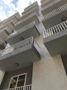 - un bâtiment avec des balcons blancs sur le côté dans l'établissement Lovely holiday home next to Bus terminus, à San Pawl il-Baħar
