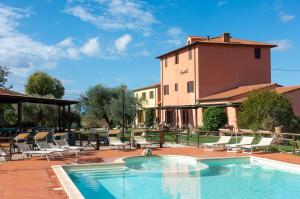 a swimming pool with chairs and a building at Villa Brancatelli in Riotorto