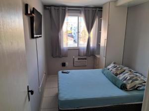 Habitación pequeña con cama y ventana en Solar do Pontal - Lindo Apartamento a 600m da praia, en Río de Janeiro