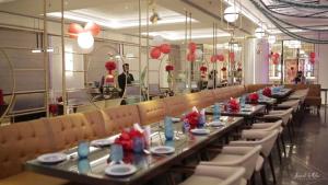 un comedor con mesas largas, sillas y globos rojos en Hotel Maharaja Palazzo en Ludhiana
