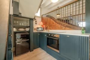 a kitchen with blue cabinets and a staircase at The Old Stables in Newcastle upon Tyne
