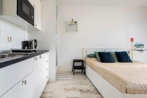 uma cozinha com uma cama e um lavatório num quarto em 010 Studio City Center Rotterdam em Roterdã