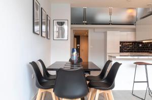 uma sala de jantar com uma mesa e cadeiras pretas em Palm Tree House - Angles Max em Orpington