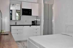 a white room with a bed and a kitchen at 010 Studio City Center Rotterdam in Rotterdam