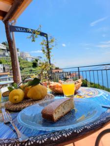 una mesa con un plato de pan y zumo de naranja en Villa Pino, en Furore