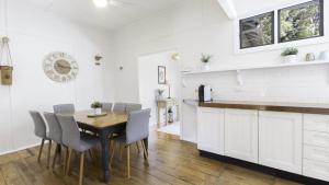 eine Küche und ein Esszimmer mit Tisch und Stühlen in der Unterkunft 'Wagstaffe Cottage' by HolidayCo in Booker Bay