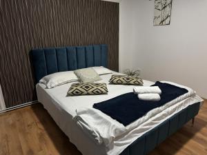 a bed with a blue headboard and pillows on it at Muresenilor Residence in Braşov