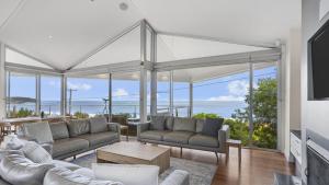 a living room with couches and a view of the ocean at 'A Beachside Getaway - 8' by HolidayCo in Killcare