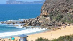 a beach with a bunch of people on it at 'A Beachside Getaway - 8' by HolidayCo in Killcare +14 photos