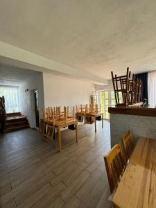 a dining room with wooden tables and chairs at Casa de la Baltă in Rieni
