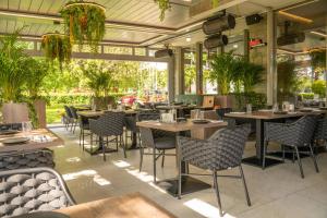 a restaurant with tables and chairs and plants at Exclusive Hotel & More in Sibiu