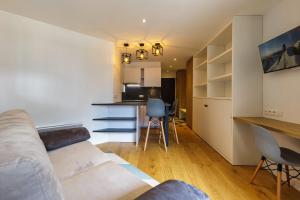 ein Wohnzimmer mit einem Sofa und einer Küche in der Unterkunft Chamonix Sud - Lognan 106 - Happy Rentals in Chamonix-Mont-Blanc