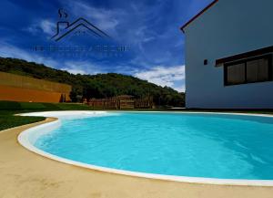 a large blue swimming pool in front of a building at El Pico de Aroche in Aroche