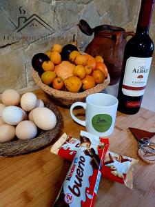 twee manden fruit en eieren op een tafel met een fles wijn bij El Pico de Aroche in Cortegana