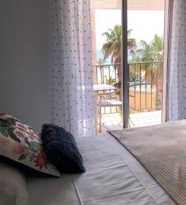 a bedroom with a bed with a view of a balcony at Anglade Hotel in Le Lavandou