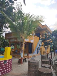 VISHWVRUND HOME STAy في Rājpīpla: منزل أمامه نخلة