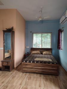 VISHWVRUND HOME STAy في Rājpīpla: غرفة نوم بسرير كبير في غرفة بجدران زرقاء +3 صور