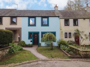 a blue and white house with a driveway at 32 Friar Row in Wigton