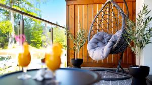 a hanging hammock on a patio with a table at Apartamenty Good Time- Stone Hill II in Szklarska Poręba